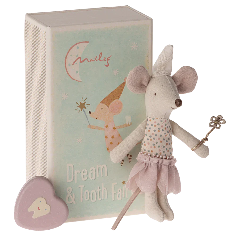 A Maileg Tooth Fairy Mouse, Little Sister in Match Box, stands beside a small book with "Dream & Tooth Fairy" written on the cover. A small heart-shaped tooth box sits nearby, ready for bedtime magic under cozy bedlinen.