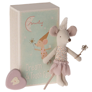 A Maileg Tooth Fairy Mouse, Little Sister in Match Box, stands beside a small book with "Dream & Tooth Fairy" written on the cover. A small heart-shaped tooth box sits nearby, ready for bedtime magic under cozy bedlinen.