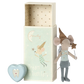 The Maileg Tooth Fairy Mouse in Matchbox, Blue, dressed as a tooth fairy, stands next to an open box labeled "Dream & Tooth Fairy" and a small heart-shaped tooth box with a tooth design on it, ready to deliver sweet dreams.