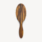 The Machete Petite Travel Detangling Hair Brush is shown on a plain white background, featuring a brown tortoiseshell-patterned design crafted from luxurious Italian acetate, with an oval head and sturdy handle.