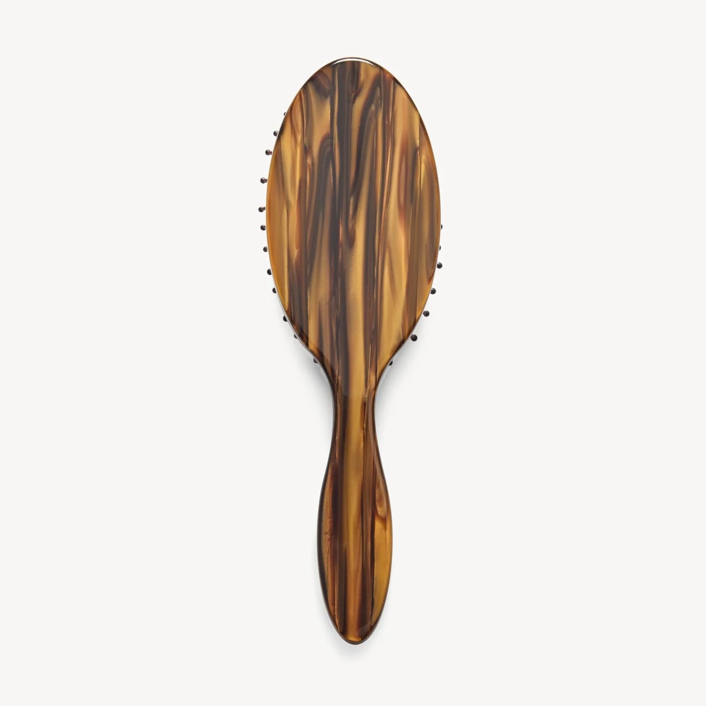 The Machete Petite Travel Detangling Hair Brush is shown on a plain white background, featuring a brown tortoiseshell-patterned design crafted from luxurious Italian acetate, with an oval head and sturdy handle.
