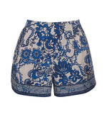 Cara Cara Trish Shorts by Cara Cara feature a blue and white floral lace design with a high waist and intricate patterns, complete with an elastic waistband for comfort.