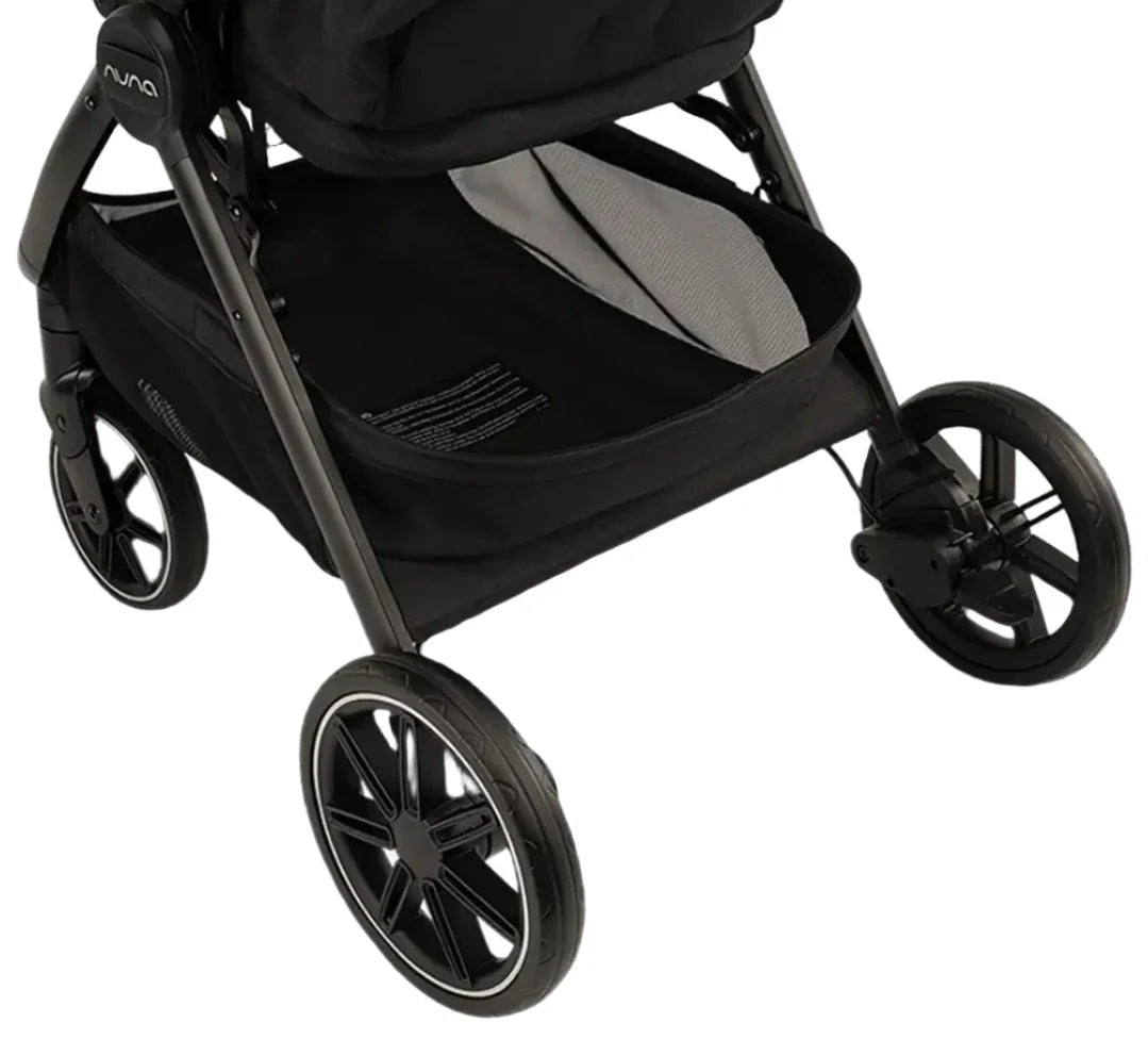 Close-up of the lower section of the Nuna TRVL lx Stroller by Nuna, highlighting the basket beneath the seat and the front wheel assembly, designed for compact freedom and ease.