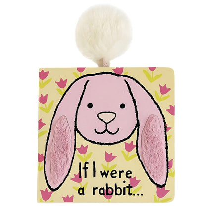 The Jellycat "If I Were A Rabbit" book by Jellycat is a charming yellow and pink children’s book featuring a drawn bunny face, with soft, floppy ears and a fluffy white pom-pom tail on top—perfect for bedtime storytelling.