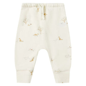 The Quincy Mae Baby Drawstring Pant, crafted from organic brushed jersey, features an elastic waistband and a subtle animal and tree print in soft off-white and neutral tones.