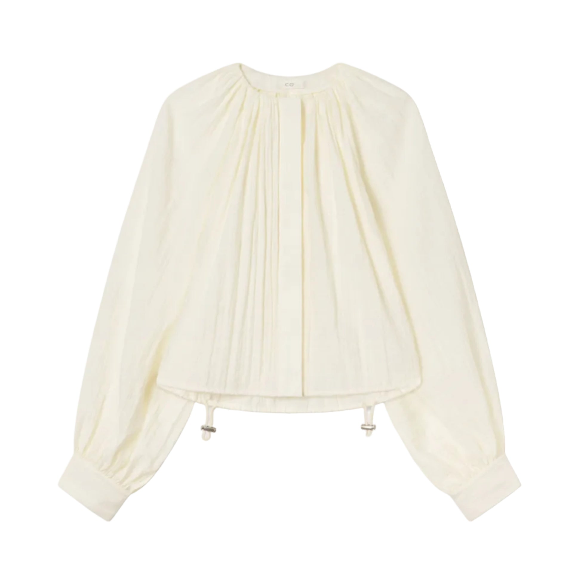 The Gathered Shirt by CO is a long-sleeved, off-white blouse featuring front pleats, a round-neck silhouette, buttoned cuffs, and an adjustable toggle drawstring hem for a custom fit.