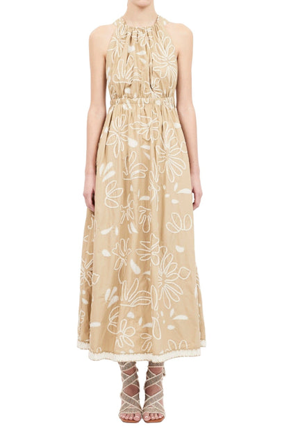 A person is wearing a beige, sleeveless, ankle-length Ulla Johnson Viola Dress with embroidered florals and strappy heels.