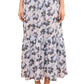A person wearing the Ulla Johnson Olina Midi Skirt, a light-colored cotton-blend skirt with blue and black abstract print, styled with tan strappy sandals.