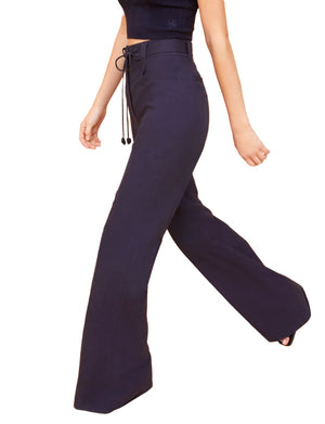 Person wearing Ulla Johnson Daya Pant and a black crop top, walking to the right.