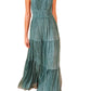 A person wearing the Ulla Johnson Freesia Gown, a sleeveless, floor-length dress in teal crinkle chiffon with a fitted waist, flowing silhouette, and pleated skirt.