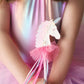 A girl in a shiny pink dress holds the Great P Fanciful Unicorn Wand by Great Pretenders, adorned with ribbons and a tutu, ready for fairy-tale fun.