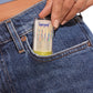 A person slips a Supergoop Unseen Sunscreen Stick SPF 40 into the front pocket of blue denim jeans for invisible sun protection that works even over makeup.