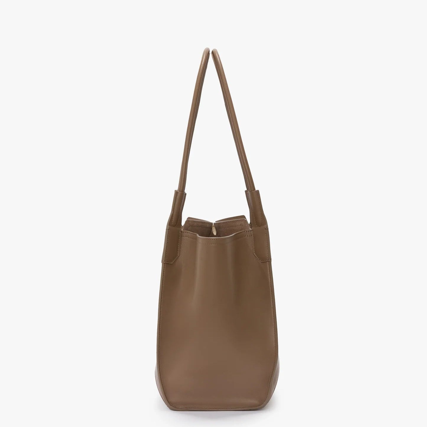 The Victoria Beckham Victoria Tote in taupe leather, featuring two handles and a suede lining, Italian crafted, is shown standing upright against a plain white background.