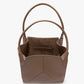 The Victoria Tote by Victoria Beckham is a taupe Italian leather tote with two handles, an open top, suede-lined interior, and a small inner pocket.
