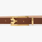 The Victoria Beckham Pin Buckle Dorian Belt, crafted from dark tan calf leather and featuring a gold, stylized pin buckle, is displayed against a plain white background.