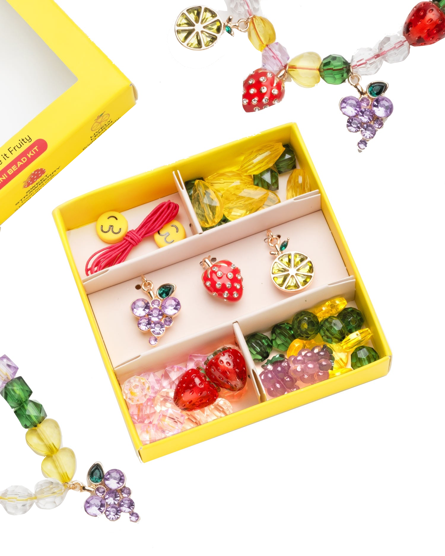The Make It Fruity Mini Bead Kit by Super Smalls features colorful fruit-inspired charms and berry-bright beads—strawberries, grapes, lemons, and smiley faces—all neatly organized in compartments.