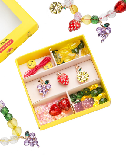 The Make It Fruity Mini Bead Kit by Super Smalls features colorful fruit-inspired charms and berry-bright beads—strawberries, grapes, lemons, and smiley faces—all neatly organized in compartments.
