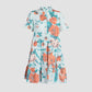 The Erdem Trailing Poppy Short Shirt Dress is a light blue cotton sateen midi with short sleeves, a tiered skirt, and a vibrant orange and pink poppy print.