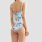 Model wears the Erdem Trailing Poppy One Piece, a floral swimsuit with detachable shoulder straps, shown from the back against a plain light grey background.