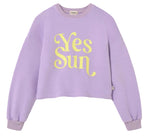 The Cozmo Girls' Vega Sweatshirt is a lavender fleece with a crew neck, long sleeves, and a bold "Yes Sun" motif in large yellow letters on the front.