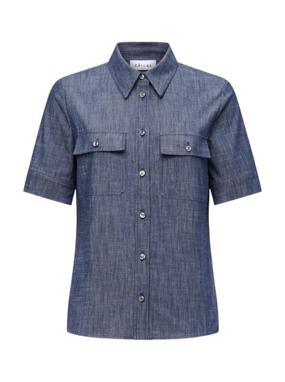 The Vesper Top by Callas Milano is a short-sleeved, button-up denim shirt with a collar and two front pockets, all in a rich Indigo color that exudes retro appeal.