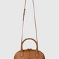 Brown leather Victoria Small Doctor Bag by Victoria Beckham with top handles and an adjustable crossbody strap, displayed against a plain white background.