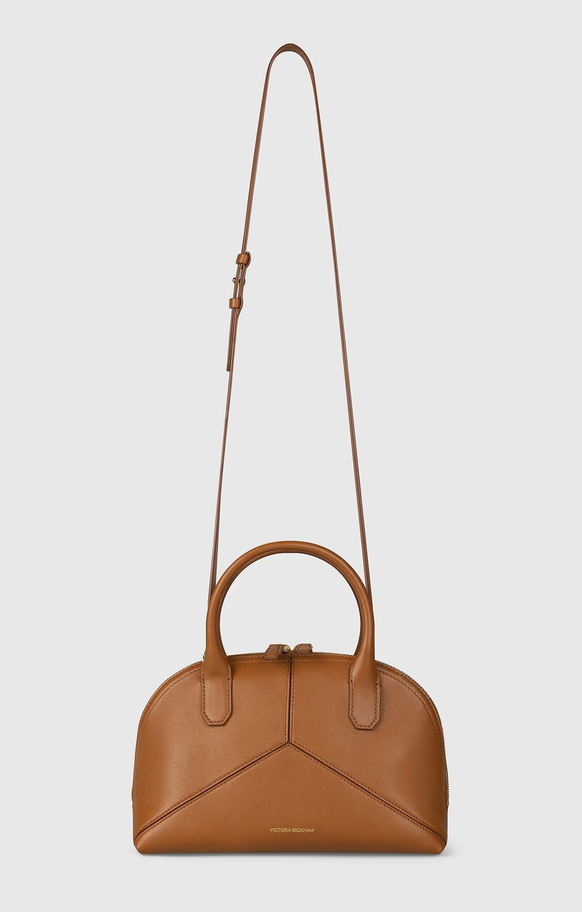Brown leather Victoria Small Doctor Bag by Victoria Beckham with top handles and an adjustable crossbody strap, displayed against a plain white background.
