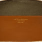 Close-up of a brown leather Victoria Small Doctor Bag interior by Victoria Beckham, featuring a gold zipper, embossed text, and crossbody strap attachment space.