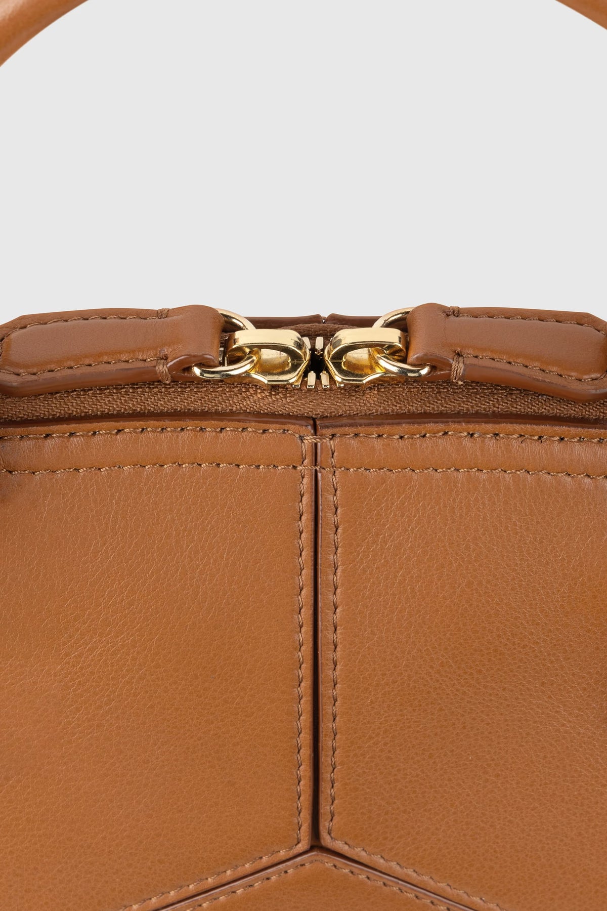 Close-up of a brown leather Victoria Small Doctor Bag by Victoria Beckham with visible stitching, gold clasp, and adjustable crossbody strap.