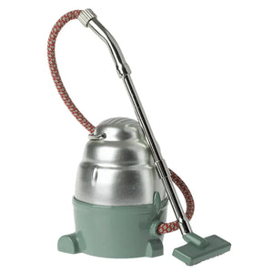 The Maileg Vacuum Cleaner features a retro design with a metal body, red-and-white braided hose, and gray floor attachment—perfect for tiny mice to tidy their homes in style.