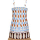The Valencia Mini Dress by Cara Cara features a sleeveless mini shift silhouette with thin straps, a blue, brown, and beige geometric pattern, back zipper, and raffia fringe hem.