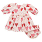 The Pink Chicken Baby Girls' Renee Dress Set features puffed sleeves and matching bloomers, with a pink and red gradient heart pattern on white—perfect for Valentine’s Day.