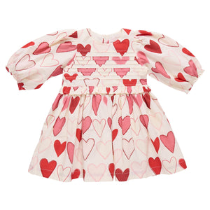 The Pink Chicken Girls' Renee Dress features long sleeves, a cream color with pink and red gradient hearts, and a gathered waist—perfect for Valentine’s Day.
