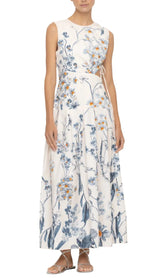 Person wearing an Agua By Aguabendita Otono Midi Dress, a sleeveless, white maxi dress with a blue and orange floral pattern from Agua By Aguabendita, paired with strappy sandals.