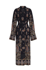 The Viv Midi Dress by Cara Cara is a long black robe-style dress showcasing a paisley and floral pattern, accented with wide sleeves and a coordinating belt at the waist, designed in the elegant style of a faux wrap dress.