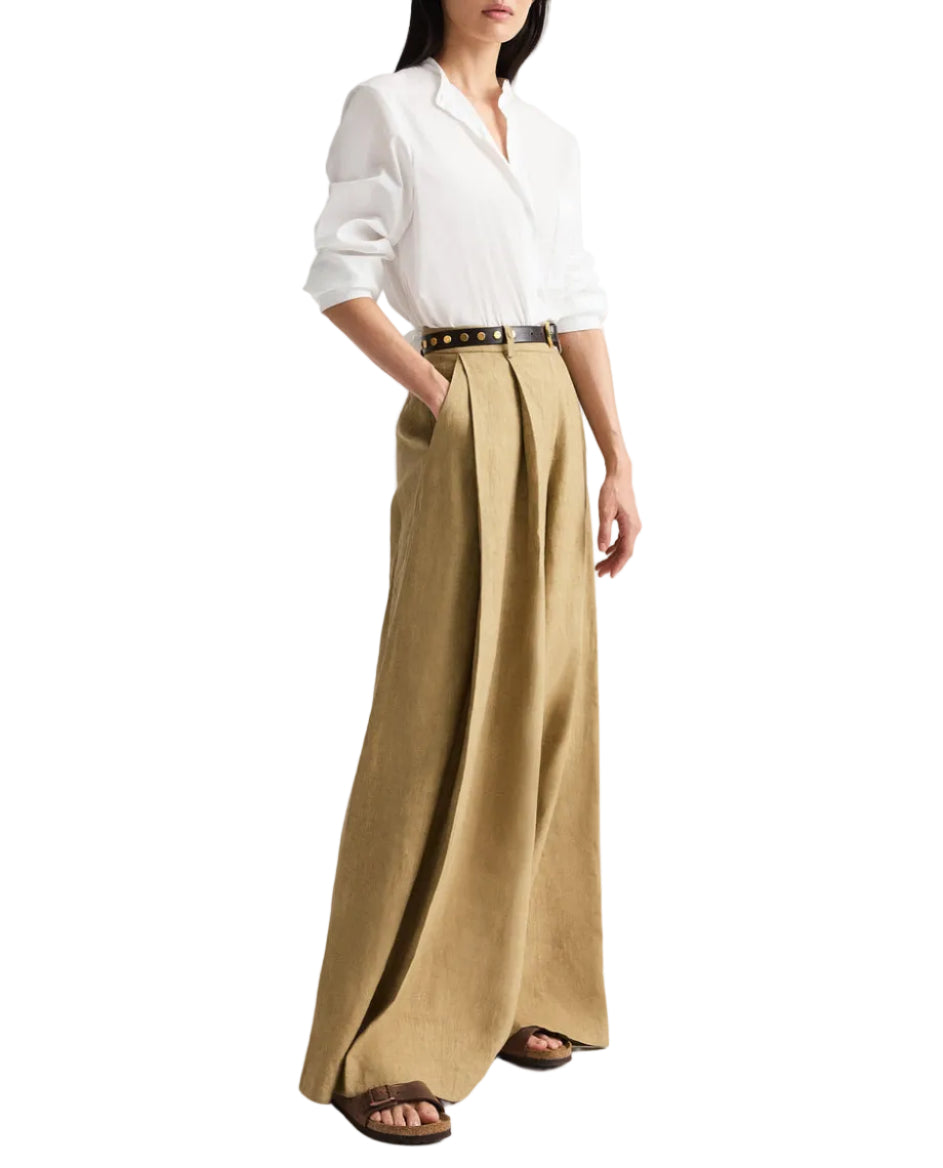 Someone wears the TWP Tied Down Shirt, a white band collar button-down, tucked into high-waisted wide-leg tan trousers with a belt and brown sandals.