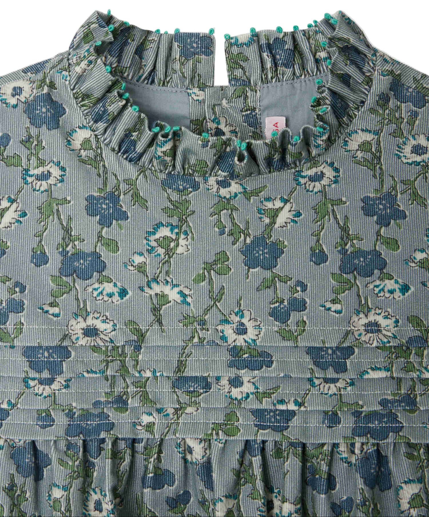 Close-up of Bonpoint's Girls' Topaz Dress, featuring an embroidered collar, button back closure, and pleated Liberty velvet fabric in blue and green.