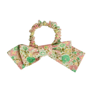The Bonpoint Jeani Scrunchie in Pink Liberty Fabric features a floral design and a large matching bow in soft pastel shades.