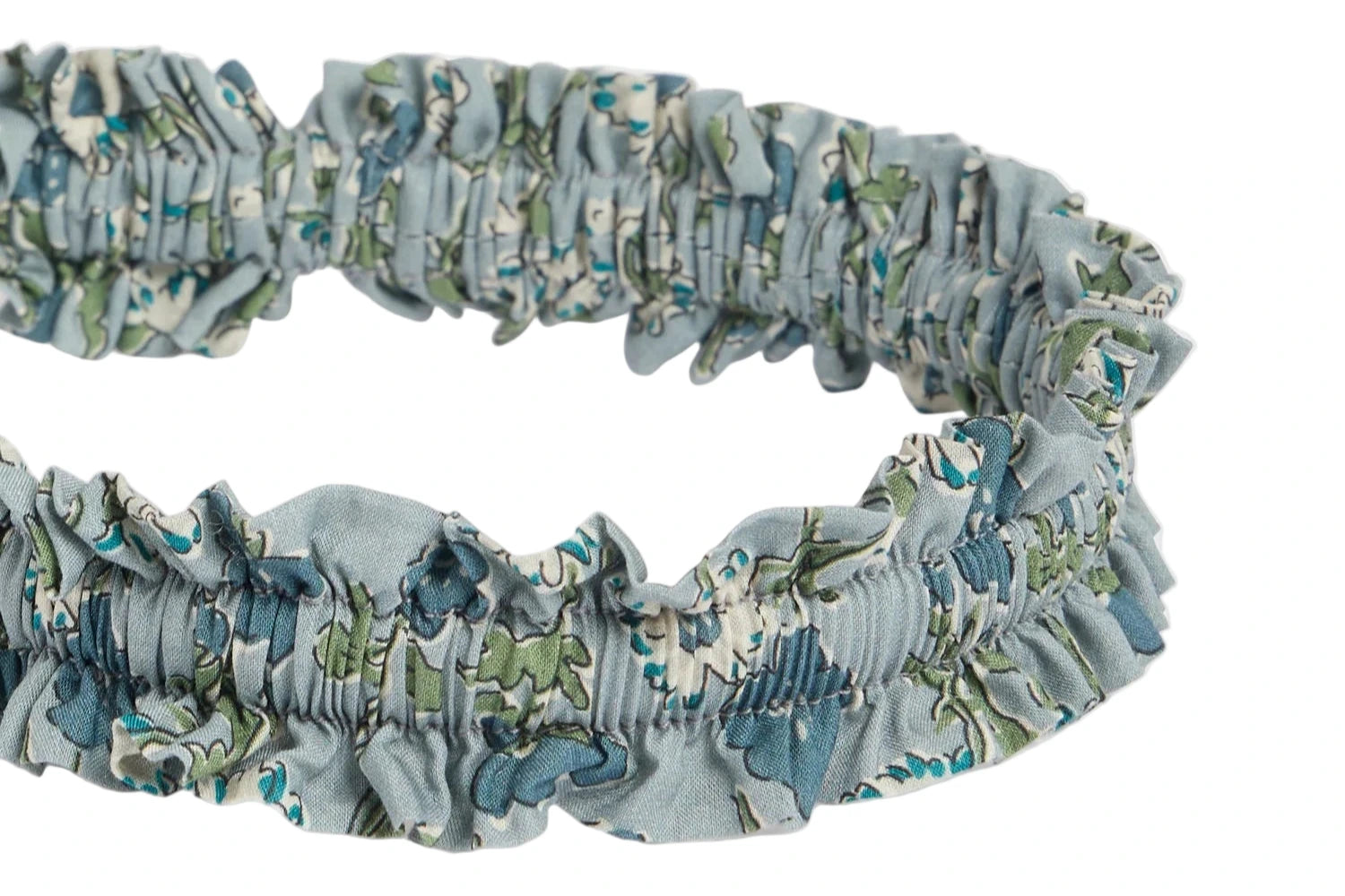 A close-up of the Bonpoint Jovie Headband, crafted from blue organic cotton Liberty fabric, displayed against a white background.