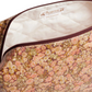 The Trousse Quilted Pencil Case in Liberty Fabric by Bonpoint features coated cotton, a zippered closure, white lining, and a label reading “Bonpoint Made in Hungary”—ideal for storing baby essentials or stationery.