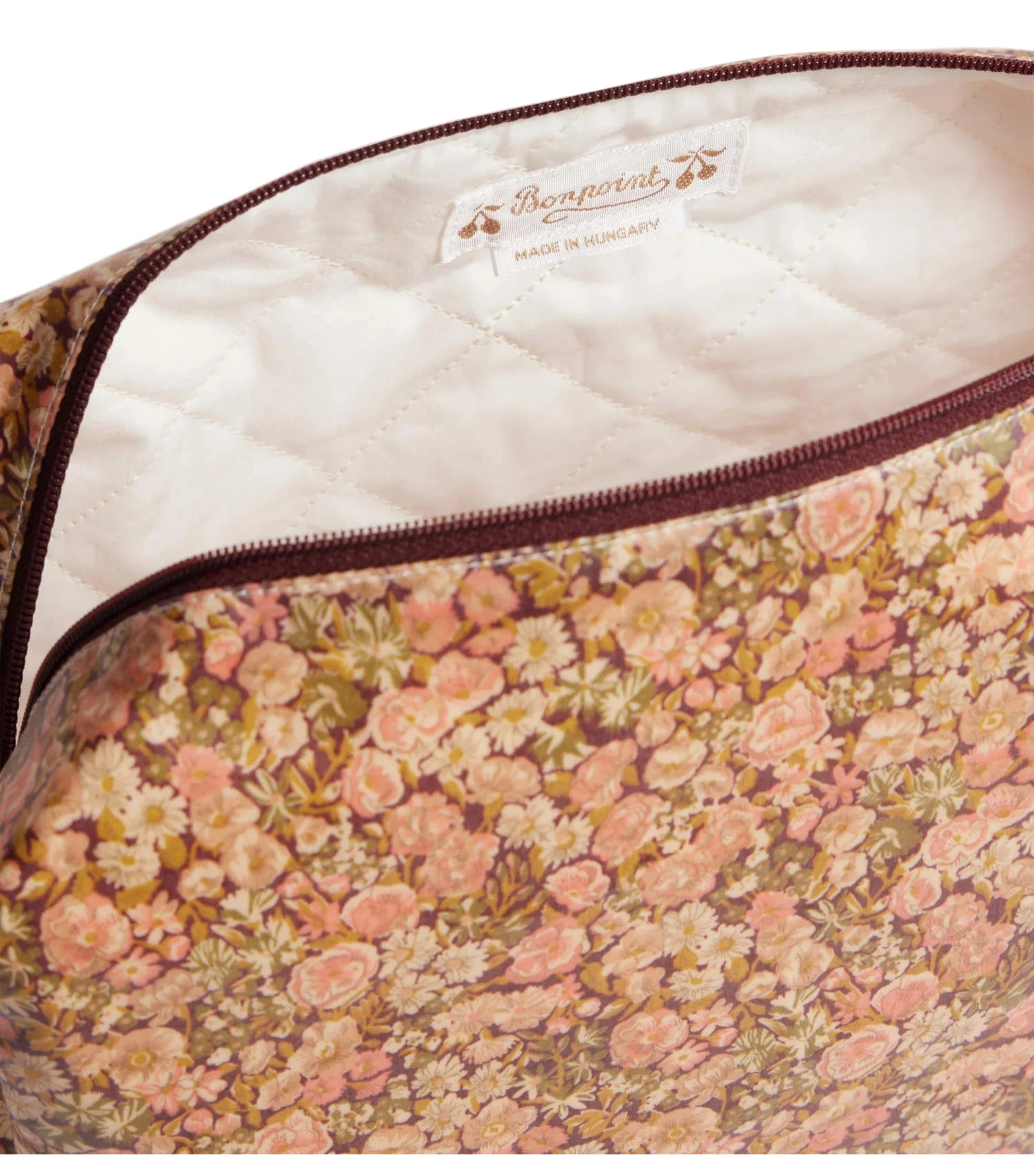 The Trousse Quilted Pencil Case in Liberty Fabric by Bonpoint features coated cotton, a zippered closure, white lining, and a label reading “Bonpoint Made in Hungary”—ideal for storing baby essentials or stationery.