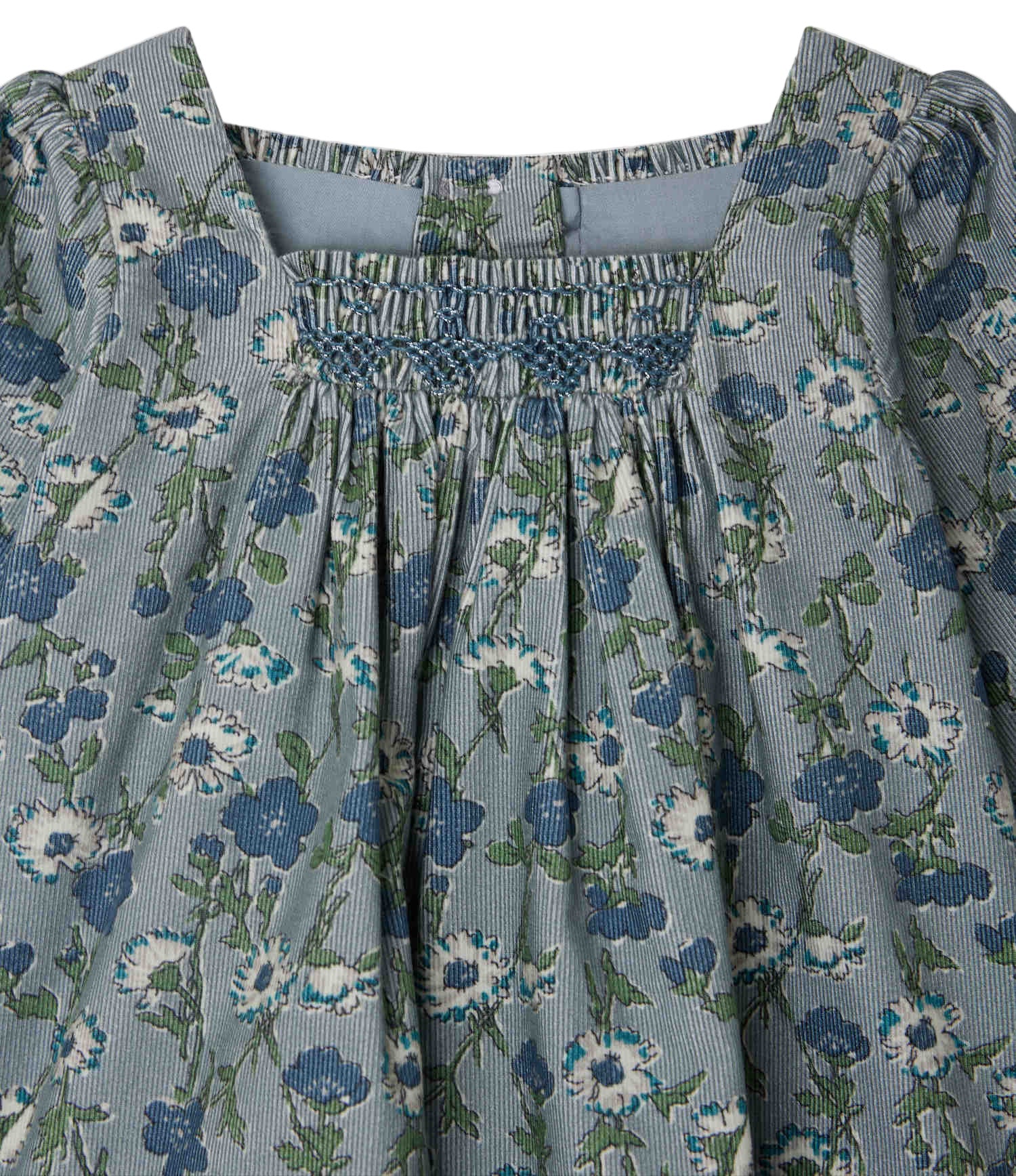 Close-up of Bonpoint’s Baby Girls' and Girls' Jada Smocked and Embroidered Dress, featuring blue and white florals, a square neckline, smocked chest, gathered fabric, and crafted from soft Liberty velvet.