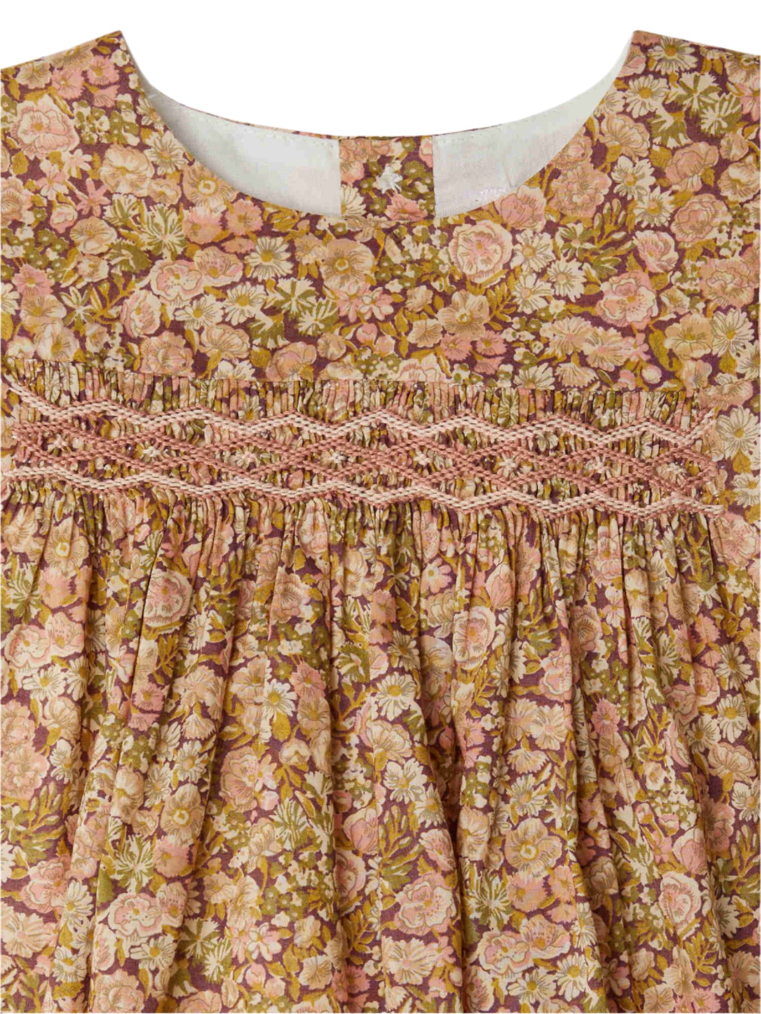 Close-up of the Bonpoint Baby Girls' and Girls' Félicie Smocked Dress made with Liberty Fabric, featuring a pink and yellow floral motif, smocked chest detailing, and a rounded neckline.