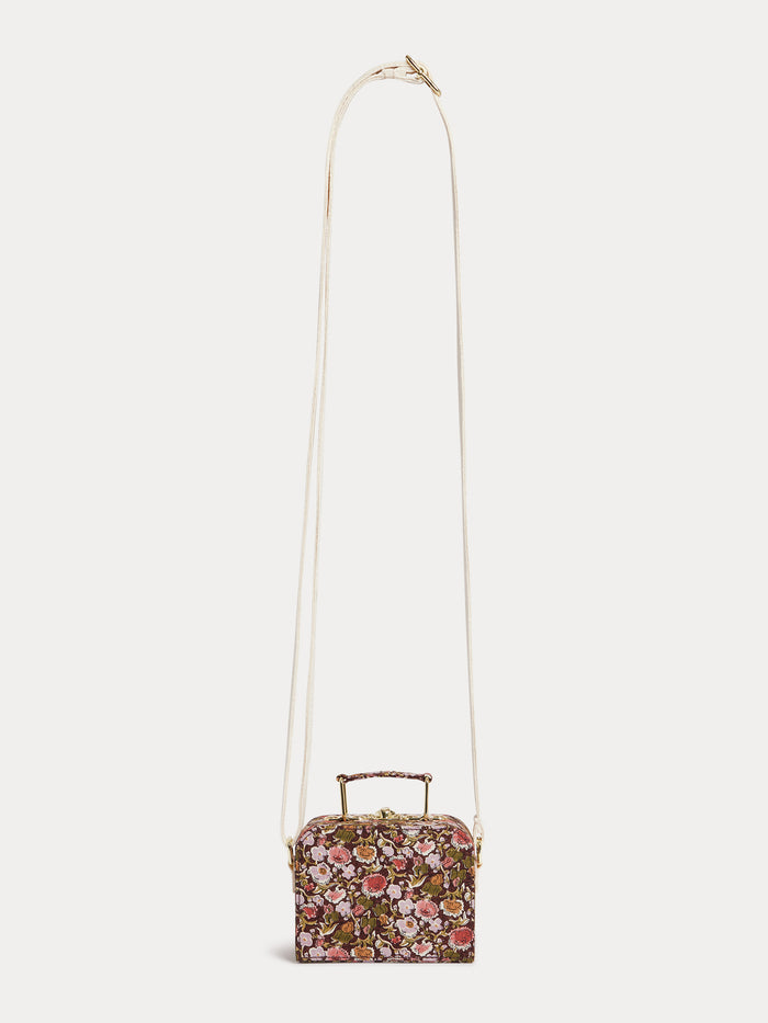 The Girls’ Aimane Travel Bag by Bonpoint is a small floral-patterned handbag crafted from organic cotton, featuring a top handle and a long, thin white strap, displayed against a plain white background.