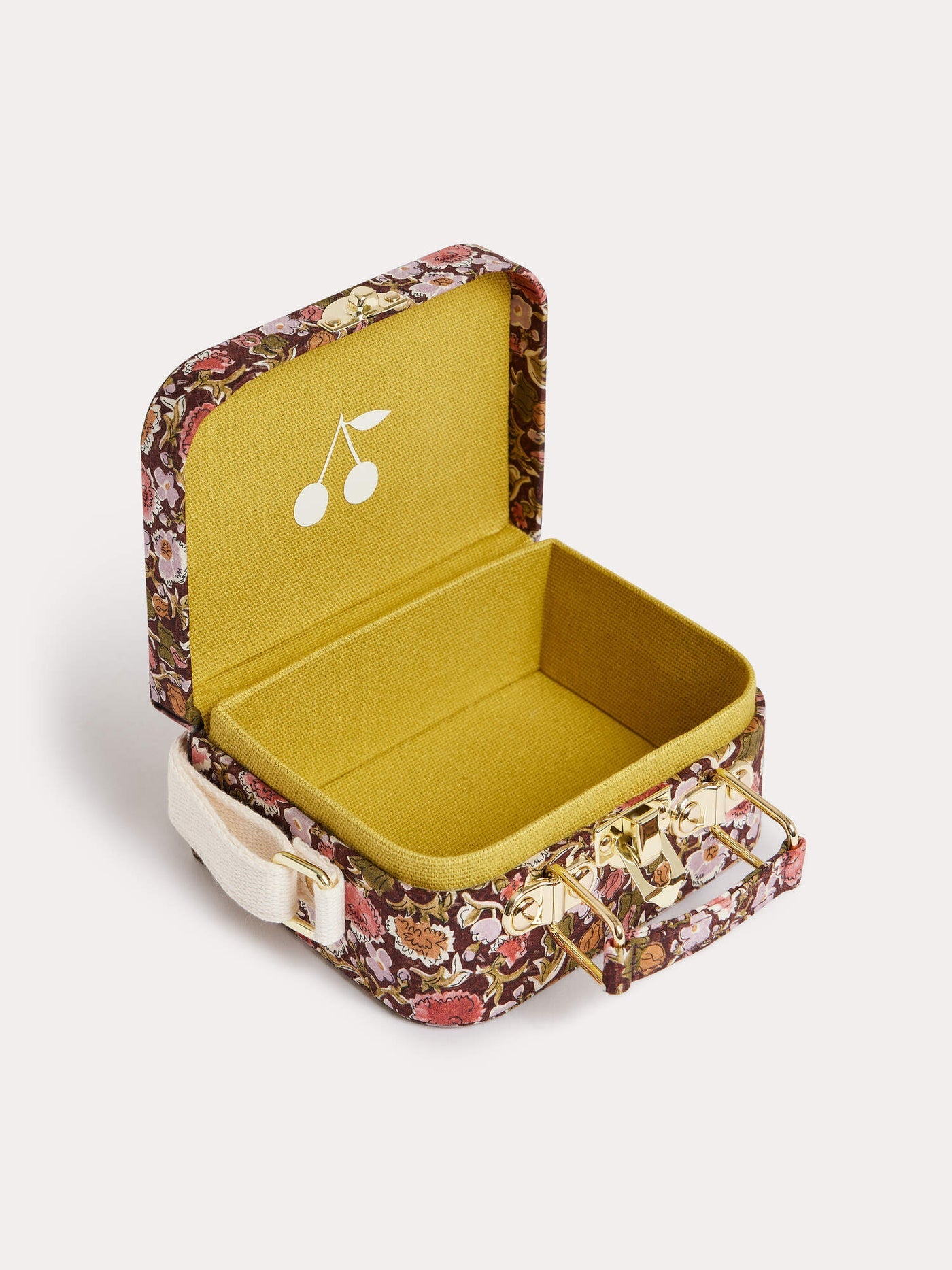 Introducing the Girls’ Aimane Travel Bag by Bonpoint—a small box crafted from Liberty fabric featuring a floral pattern, designed with an open lid, a yellow interior adorned with a white cherry motif, and finished with a beige strap attached to the side.