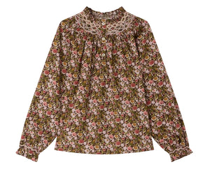 The Girls’ Petale Blouse by Bonpoint is a long-sleeve top made from Liberty fabric, showcasing a multicolored floral print, ruffled cuffs, a lace collar, and front buttons, displayed on a white background.