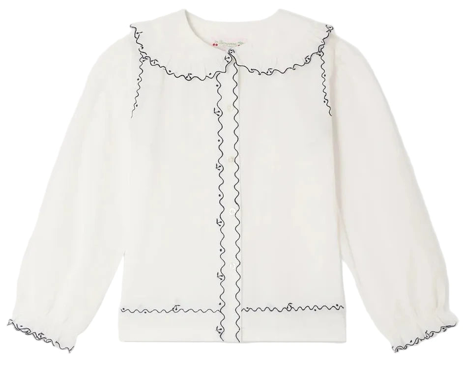 Bonpoint Girls’ Maneke Blouse with Peter Pan Collar Embroidery, a white long-sleeve blouse adorned with a ruffled vintage Peter Pan collar and wavy black trim accenting the collar, button placket, cuffs, and hem.