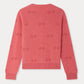 Back view of the Bonpoint Girls’ Manon Cardigan in pink, showcasing a subtle cherry pattern with ribbed cuffs, hem, and collar, displayed against a plain white background.