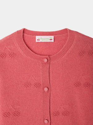 Close-up of the Bonpoint Girls’ Manon Cardigan, featuring a round neckline, cherry embroidery, and matching pink buttons. The signature Bonpoint label with cherries and text is sewn inside the collar, showcasing this cashmere cardigan’s distinctive style.