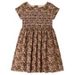 The Girls’ Duchesse Dress by Bonpoint features a short-sleeve silhouette with a floral print in pink, green, and brown tones. Made from soft organic cotton Liberty fabric, it includes a smocked bodice and gathered skirt for an elegant look.